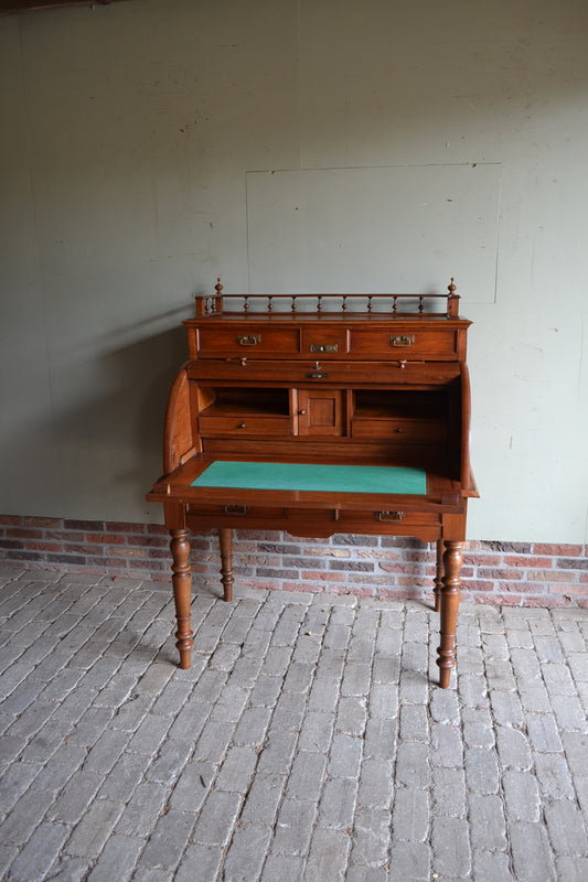 Antiek noten Art Deco cylinderbureau met achter de klep diverse vakjes en laatjes. Een uitschuifbaar werkblad wat ingelegd is met groen vilt. Onder en boven heeft het bureau 2 laden. Antieke schrijftafel, antieke secretaire, antiek buro. Antiek Art Deco bureau.
