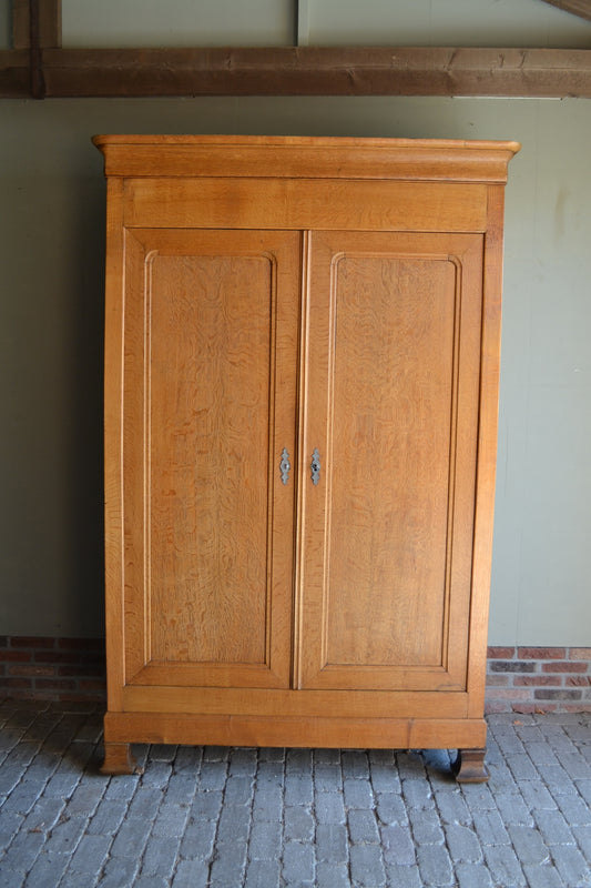 Antieke strakke eiken houten Louis Philippe kast met twee deuren voorzien van panelen. Achter de deuren planken en laden. Antiek kledingkast, antieke linnenkast, antieke opbergkast, antieke Franse kast, antieke eiken kast, antieke woonkamerkast, antieke slaapkamerkast.