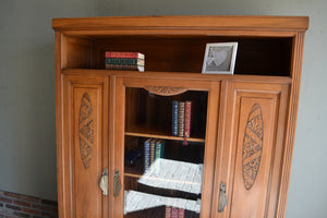 Antieke eiken Art Deco kast, antieke eiken boekenkast met boven een open vak en eronder drie deuren waarvan de middelste voorzien is van glas. De twee buitenste deuren hebben panelen in de deuren. antieke boekenkast, antieke vitrinekast, antieke servieskast, antieke winkelkast, antieke bibliotheekkast.