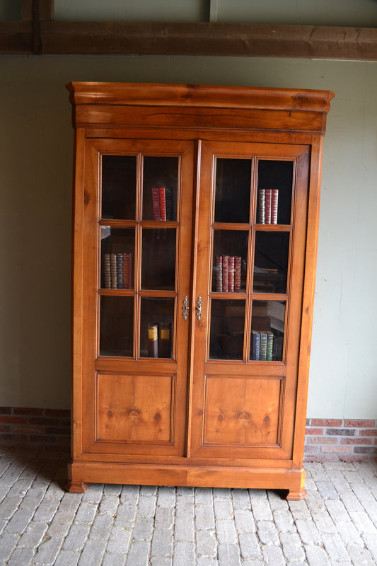 Antieke kersen houten Louis Philippe boekenkast met beglaasde deuren met roedeverdeling. Achter de twee deuren planken. Antieke winkelkast, antiek vitrinekast, antieke servieskast, antieke bibliotheekkast. antieke kantoorkast, antieke opbergkast, antieke Franse kast, antieke woonkamerkast, antieke keukenkast.