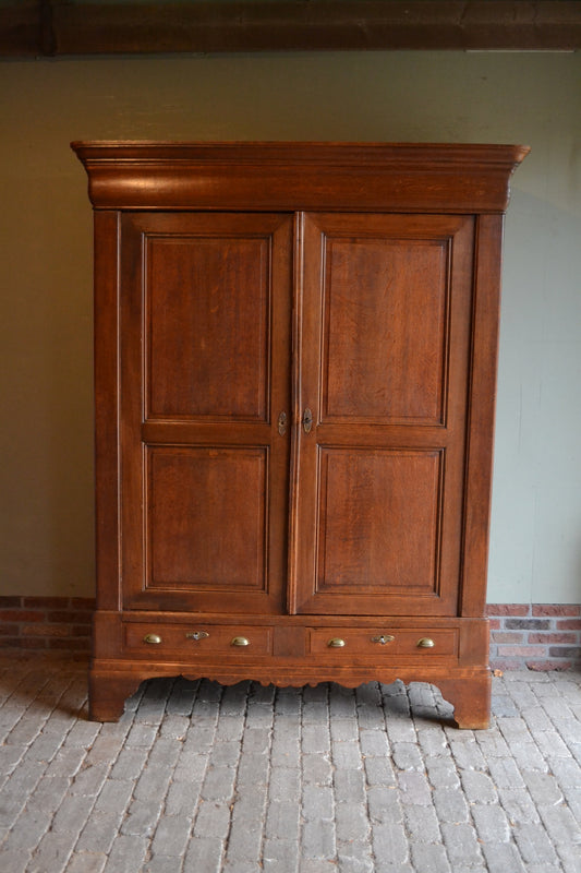 antieke eiken houten Louis Philippe kast met twee deuren en in elke deur twee panelen. Achter de twee deuren planken en onder de deuren twee laden. antieke Franse kast, antieke eiken kast, antieke kledingkast, antieke opbergkast, antieke linnenkast, antieke woonkamerkast, antieke keukenkast, antieke halkast, antieke garderobekast.