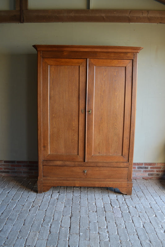 Antieke strakke eiken houten kast met twee deuren voorzien van panelen. Achter de deuren planken en onder de deuren een grote lade. Antiek kledingkast, antieke linnenkast, antieke opbergkast, antieke Franse kast, antieke eiken kast, antieke woonkamerkast, antieke slaapkamerkast.