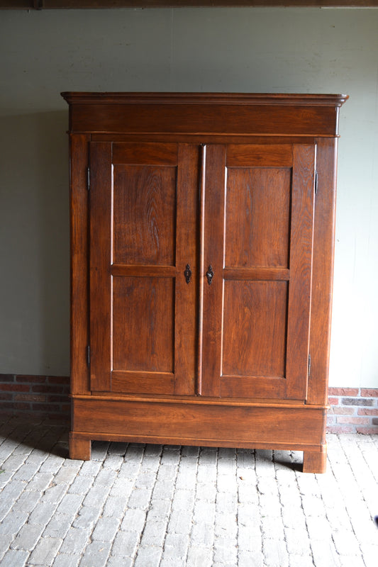 Grote antieke eiken houten Louis Philippe kast met twee deuren met twee panelen per deur. Achter de deuren planken. De antieke kast is geheel uitneembaar. antieke opbergkast, antieke linnenkast, antieke kledingkast, antieke Franse kast, antieke woonkamerkast.