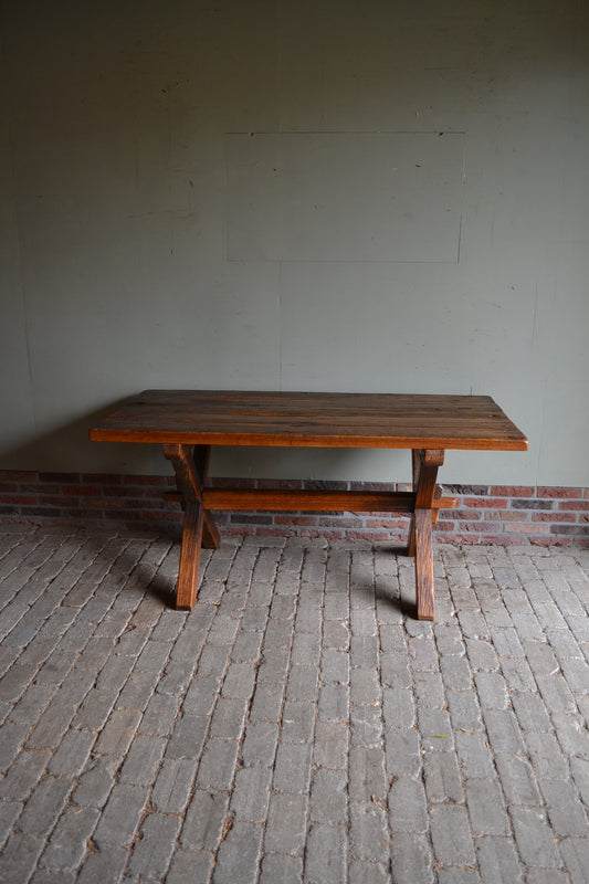 Antieke eiken houten schrijftafel met een dik robuust blad staande op een kruisvoetpoot. antieke eettafel, antiek bureau, antiek buro.