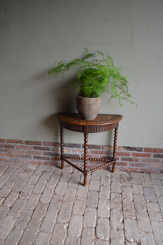 antieke eiken houten halvemaan tafel met drie gedraaide poten verbonden met een gedraaide regel. Antieke bijzettafel, antieke plantentafel, antieke wandtafel. antieke eiken tafel.
